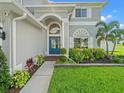 Charming front entrance with a blue door, complemented by a landscaped garden at 4805 Holdsworth Dr, Land O Lakes, FL 34639