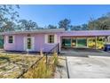 This light purple house features a carport and a white-trimmed glass door and window at 5010 109Th N Way, St Petersburg, FL 33708