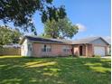 Back view of a brick home showing mature landscaping and a fenced yard at 603 Southwood Cv, Brandon, FL 33511