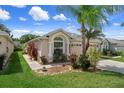 Inviting single-story home showcasing a well-manicured lawn and tropical landscaping at 6303 Gentle Ben Cir, Wesley Chapel, FL 33544