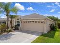A charming single-story home with a two-car garage, featuring lush landscaping and a well-maintained lawn at 6303 Gentle Ben Cir, Wesley Chapel, FL 33544