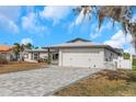 Stylish home featuring a two-car garage with gray stone driveway and manicured lawn at 6508 Senegal Palm Way, Apollo Beach, FL 33572