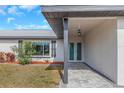 Inviting front entrance with decorative glass doors, accent lighting, and stone walkway at 6508 Senegal Palm Way, Apollo Beach, FL 33572