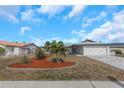 Charming single-story home with well-maintained landscaping including decorative stone and palm trees at 6508 Senegal Palm Way, Apollo Beach, FL 33572