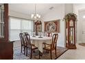 Formal dining room with elegant chandelier, table for six, and antique furniture at 6555 Sparkling Way, Wesley Chapel, FL 33545