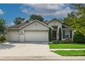 Beautiful single-story home featuring a three-car garage and meticulously maintained lawn at 6555 Sparkling Way, Wesley Chapel, FL 33545