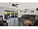 Open living room with dark floors, ceiling fans, and large sliding doors to a screened outdoor patio at 7092 119Th St, Seminole, FL 33772