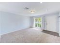 Bright living room featuring neutral walls, carpet flooring, and a large window offering natural light at 727 Kensington Lake Cir, Brandon, FL 33511
