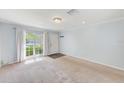 Bright living room featuring neutral walls, carpet flooring, and a large window offering natural light at 727 Kensington Lake Cir, Brandon, FL 33511