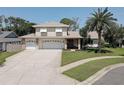 Two-story home featuring a spacious driveway leading to an attached two-car garage and mature landscaping at 7600 Drew Oak Dr, Seminole, FL 33772