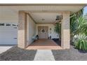 Inviting covered front porch with brick accents, cozy seating, and decorative details at 7600 Drew Oak Dr, Seminole, FL 33772