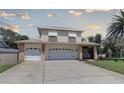 Charming two-story home featuring a spacious driveway leading to an attached two-car garage at 7600 Drew Oak Dr, Seminole, FL 33772