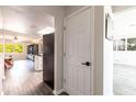 Hallway with wood flooring leading into living area and modern kitchen with white cabinets at 3254 Great Neck St, Port Charlotte, FL 33952