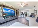 Open-concept living room with wood floors, a large TV, and a comfortable gray sectional at 3254 Great Neck St, Port Charlotte, FL 33952