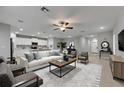 Bright, open living room features a ceiling fan, neutral color palette, and modern furnishings at 12617 Maple Bonsai Dr, Riverview, FL 33579
