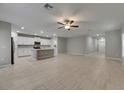 Spacious living room with modern tile flooring open to the white kitchen at 12617 Maple Bonsai Dr, Riverview, FL 33579