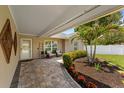 Inviting outdoor patio featuring a brick-paved walkway and lush tropical landscaping at 12804 Bert Pl, Tampa, FL 33625