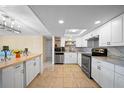 Modern white kitchen featuring stainless steel appliances, marble countertops, and a cozy breakfast nook at 12901 College Hill Dr, Hudson, FL 34667