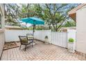 Private patio with a white fence, an umbrella, and a cozy seating area at 13205 Cypress Hill Dr, Hudson, FL 34669