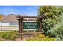 The 'Heritage Hills' community sign nestled among lush greenery and landscaping at 13727 Whiskey Daisy Dr, Dade City, FL 33525