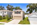 Lovely exterior of home with neutral paint, shutters, and two-car garage at 13727 Whiskey Daisy Dr, Dade City, FL 33525