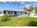 Quaint single-story blue house with white trim, a tidy front lawn, and a welcoming white picket fence at 13920 Berkowitz Ave, Hudson, FL 34667