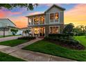 Charming two-story home with a welcoming front porch, manicured lawn, and beautiful landscaping creating curb appeal at 15936 Ternglade Dr, Lithia, FL 33547