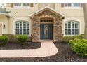 Inviting front entrance with a stone archway and decorative glass door at 16170 Colchester Palms Dr, Tampa, FL 33647