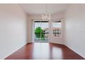 Bright living room with beautiful wood floors and sliding glass doors to balcony at 18107 Peregrines Perch Pl # 6303, Lutz, FL 33558