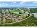 Aerial view of the community with golf course, lakes, lush greenery, nearby road, and ample parking at 1905 Oyster Catcher Ln # 924, Clearwater, FL 33762