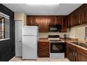 Kitchen featuring dark wood cabinetry, appliances, and laminate countertops at 1905 Oyster Catcher Ln # 924, Clearwater, FL 33762