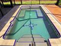 Rectangular pool with unique compass design and tiled deck at 20295 Lorenzo Ave, Port Charlotte, FL 33952