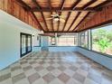 Enclosed sunroom featuring a vaulted wood ceiling, tiled floors, and sliding doors to the pool area at 20295 Lorenzo Ave, Port Charlotte, FL 33952