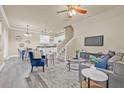 Open-concept living room showcasing modern gray floors, a ceiling fan, and views into the kitchen and dining area at 215 S Westland Ave # 3, Tampa, FL 33606