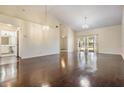 Open living room featuring vaulted ceilings, beautiful wood floors, and sliding glass doors to the outdoors at 2355 Bentley Dr, Palm Harbor, FL 34684