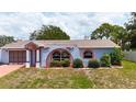 The unique arched architectural style of this home is complemented by well-maintained landscaping and freshly cut grass at 2432 Caretta Ave, Spring Hill, FL 34609