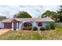 The unique arched architectural style of this home is complemented by well-maintained landscaping and freshly cut grass at 2432 Caretta Ave, Spring Hill, FL 34609