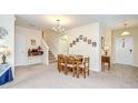 Open-concept dining area adjacent to staircase with a dining table and neutral decor at 2723 Garden Falls Dr, Brandon, FL 33511