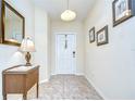 Welcoming entryway with tile flooring, a console table, decorative mirror, and elegant light fixture at 2723 Garden Falls Dr, Brandon, FL 33511