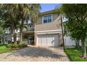 Charming two-story home boasts a large garage, brick driveway and lush landscaping with mature palm trees at 3109 W Granada St, Tampa, FL 33629