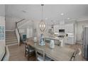 Open-concept kitchen and dining area with stainless steel appliances, ample counter space, and a staircase leading upstairs at 3161 Satilla Loop, Odessa, FL 33556