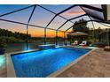 Stunning screened-in pool area with comfortable lounge chairs and a serene view of the natural surroundings, perfect for relaxation at 3161 Satilla Loop, Odessa, FL 33556