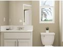 Cozy bathroom with a toilet, vanity with storage, and a window offering natural light at 36075 Risa Michele St, Zephyrhills, FL 33541