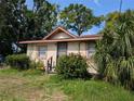 Inviting single-story home with secure metal door, framed windows, and a vibrant garden with mature tropical landscaping at 3706 N 36Th St, Tampa, FL 33610