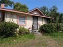 Single-story home with security door, framed windows, and natural landscaping with a tidy lawn and surrounding shrubbery at 3706 N 36Th St, Tampa, FL 33610