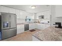 Modern kitchen features white cabinets, stainless steel appliances, and granite countertops at 4005 W Coachman Ave, Tampa, FL 33611
