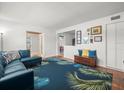 Bright living room featuring hardwood floors, a blue sofa, and a decorative palm-leaf rug at 4005 W Coachman Ave, Tampa, FL 33611