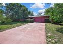 Long driveway leading to an attached two-car garage, with mature landscaping around the property at 4388 Tiffin Ave, Spring Hill, FL 34609