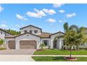 Charming white two-story home featuring a beautiful landscaped yard, tile roof, and two-car garage at 6154 Marsh Trail Dr, Odessa, FL 33556