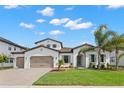 Charming white two-story home featuring a beautiful landscaped yard, tile roof, and two-car garage at 6154 Marsh Trail Dr, Odessa, FL 33556